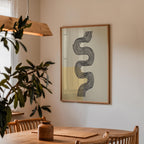 a wooden dining table with a vase on it, and a framed abstract art piece hanging on the wall above the table.