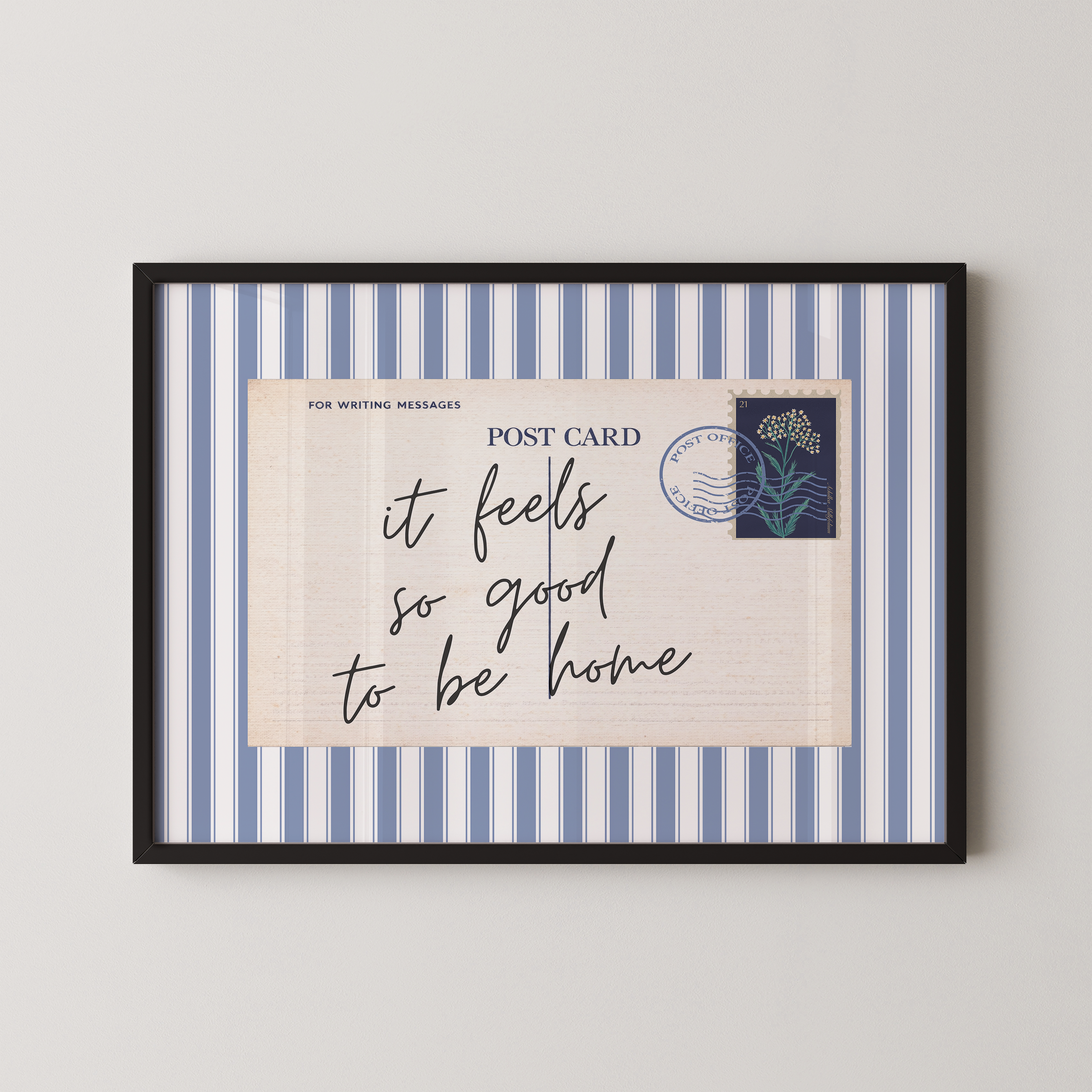 The image is a framed postcard with a blue and white striped border, featuring a handwritten message that reads "it feels so good to be home".
