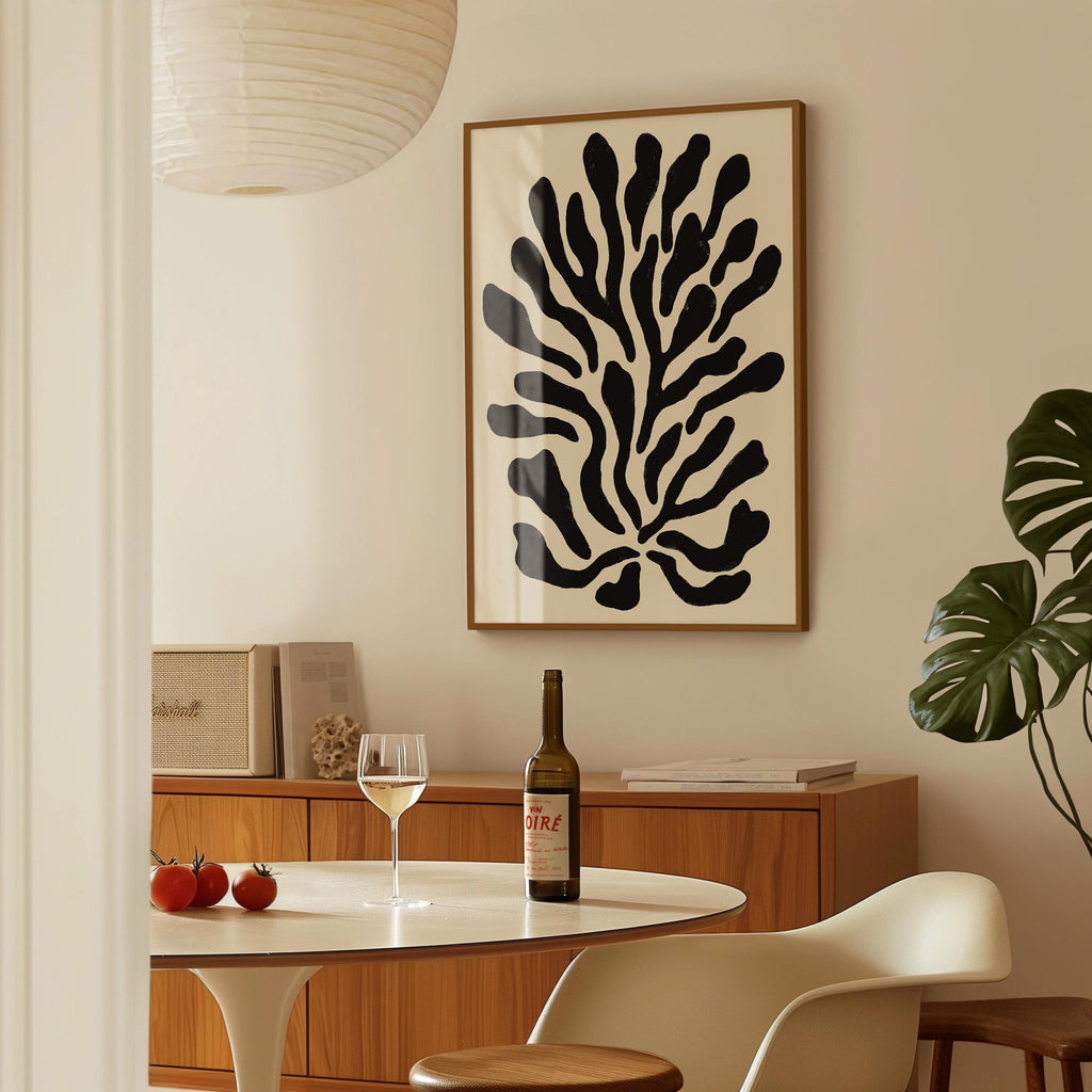a dining room with a table set for two, a bottle of wine, and a framed abstract art piece on the wall.