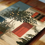 a white building with a red door and window, surrounded by lush greenery and a tree with orange fruits.