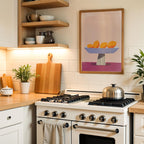 a cozy kitchen scene with a white stove, wooden cutting board, and a framed abstract painting on the wall.