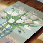 a bouquet of white tulips arranged in a vase, with two butterflies fluttering around the flowers.