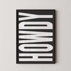 a framed poster with the word "HOWDY" written in large, bold letters.