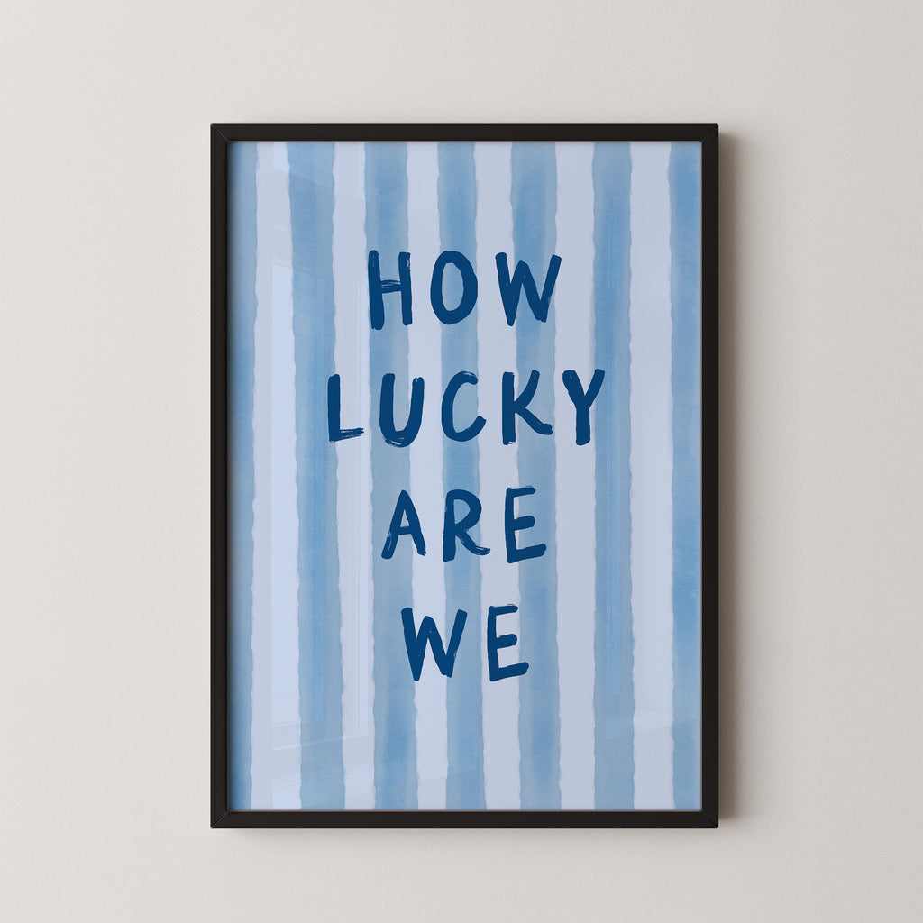 a framed poster with the text "HOW LUCKY ARE WE" written on it.