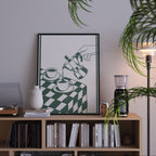 a bookshelf with a framed poster of a hand pouring coffee on a table, surrounded by various books and decorative items.