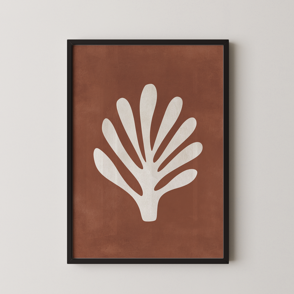 a framed print of a white leaf with a brown background.