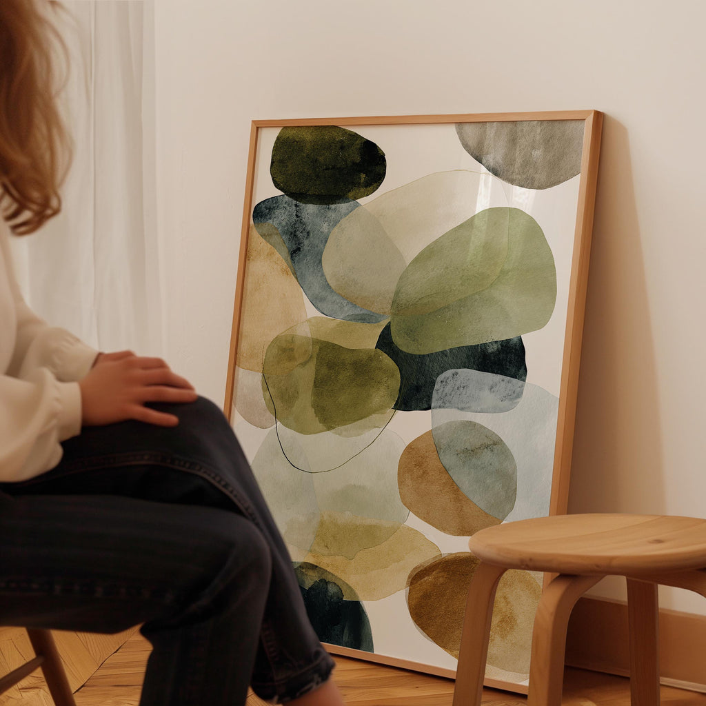 A person is sitting in a chair in front of a large abstract painting on the wall.