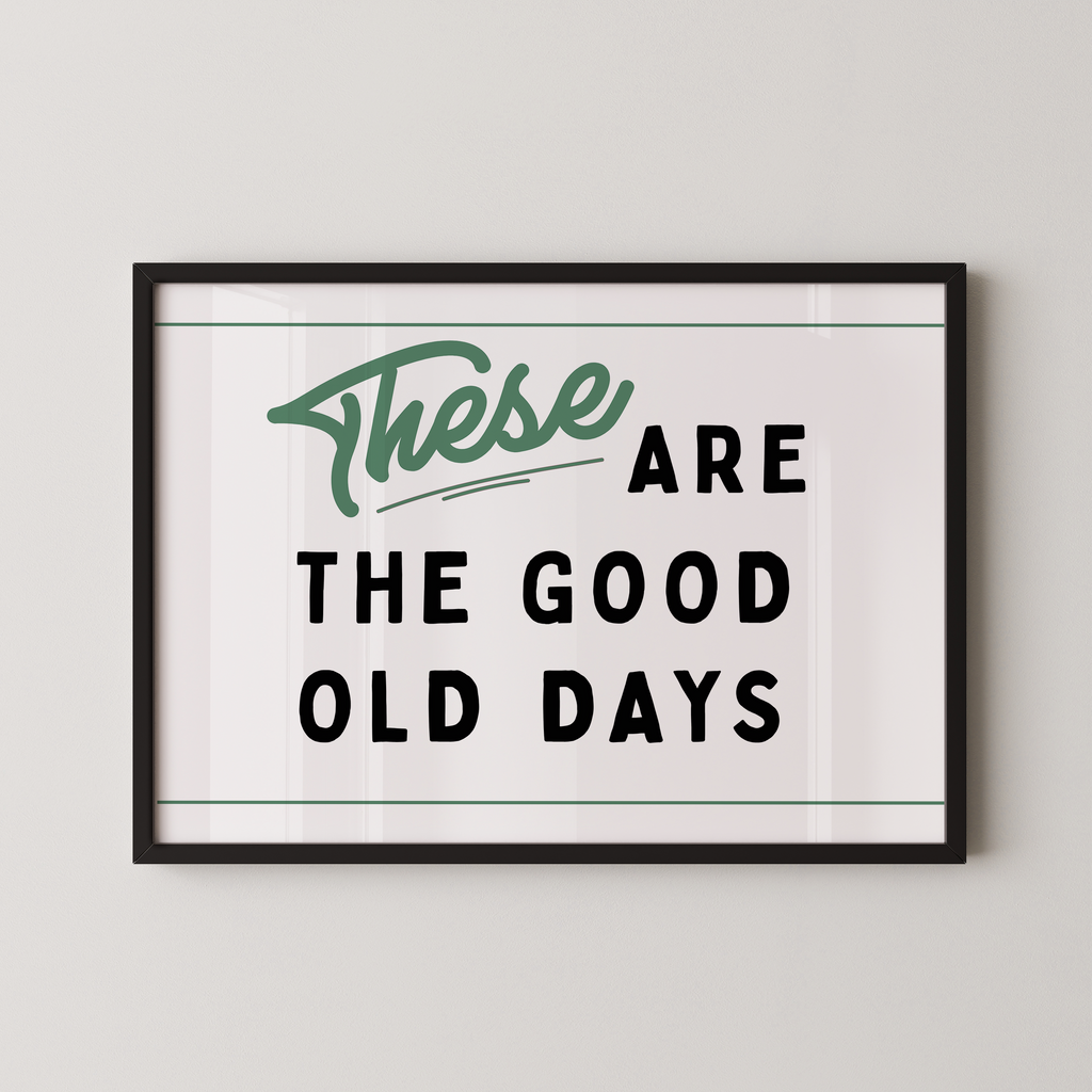 a framed poster with the text "These are the good old days" in a simple, black and green design.