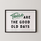 a framed poster with the text "These are the good old days" in a simple, black and green design.