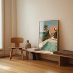 a wooden chair, a wooden bench, a vase, and a framed picture of a poolside scene with a building and palm trees.