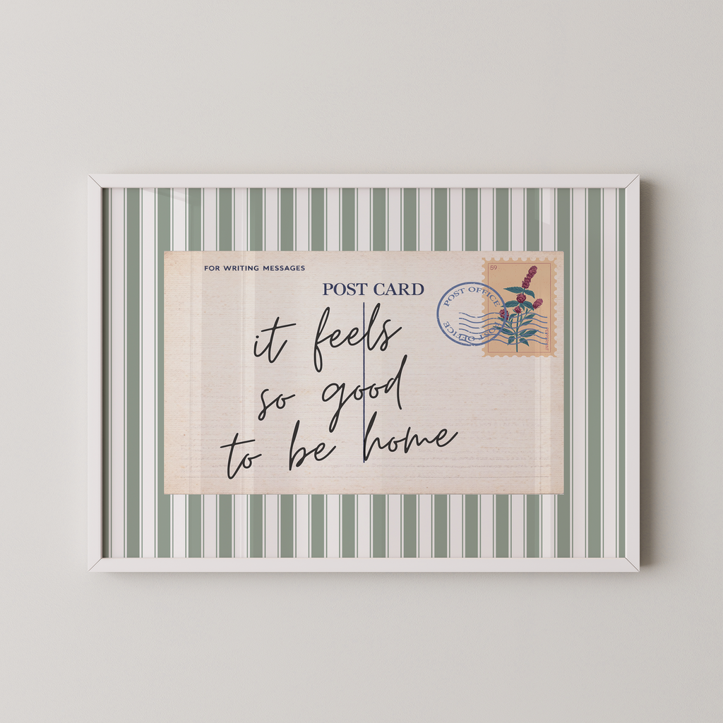 The image is a framed postcard with a handwritten message that reads "it feels so good to be home".