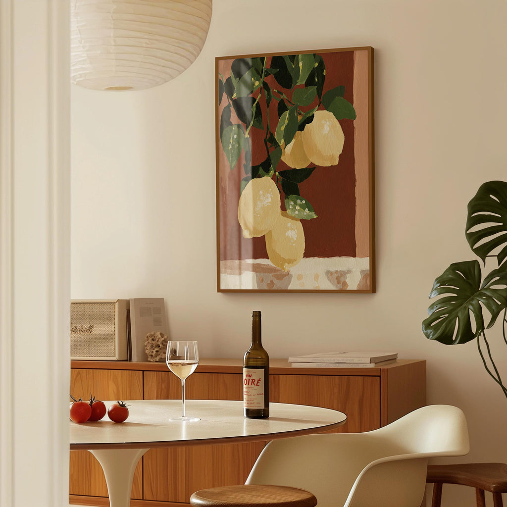 a dining room with a table set for two, a bottle of wine, and a framed painting of lemons hanging on the wall.