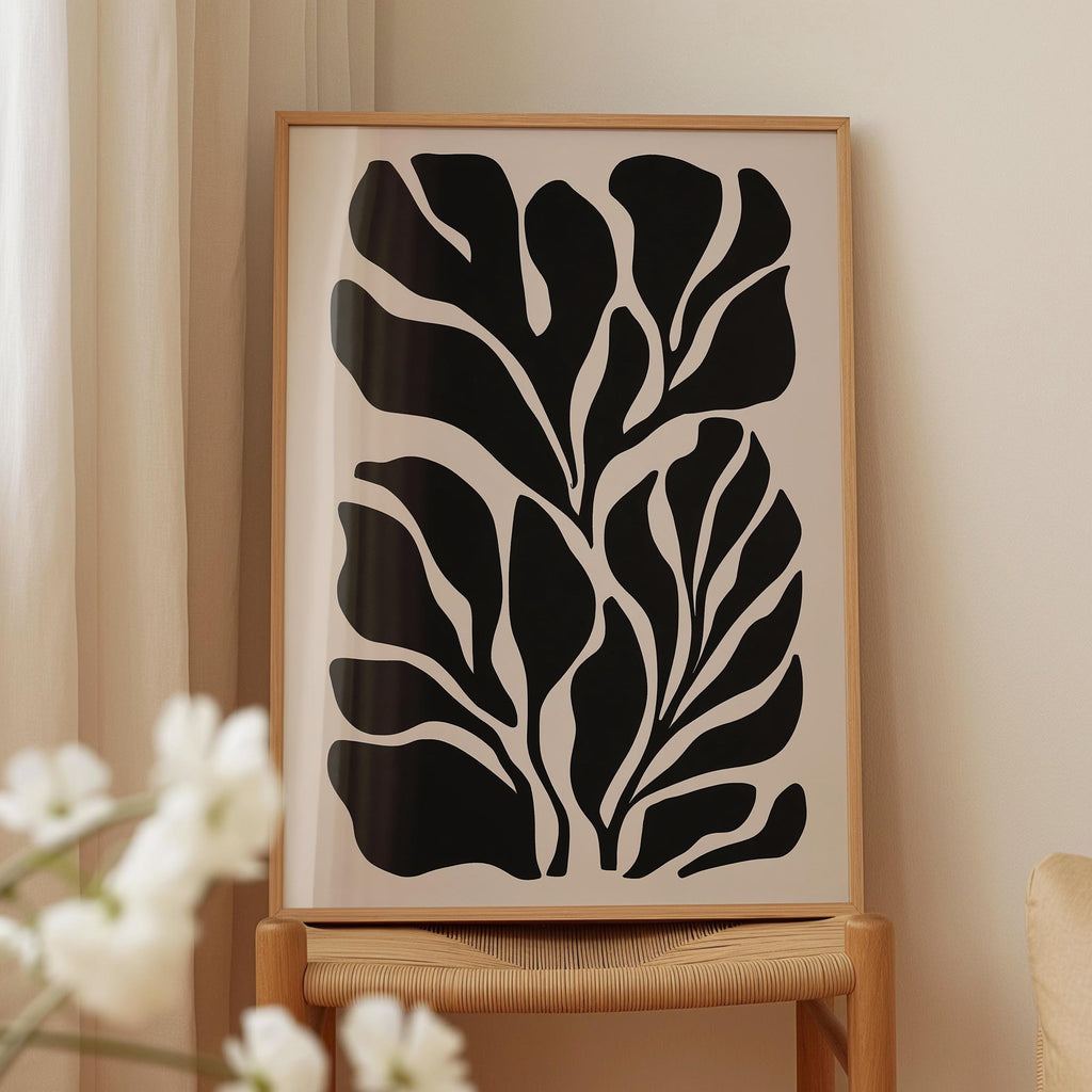 a framed artwork with a striking black and white abstract design of leaf-like shapes.