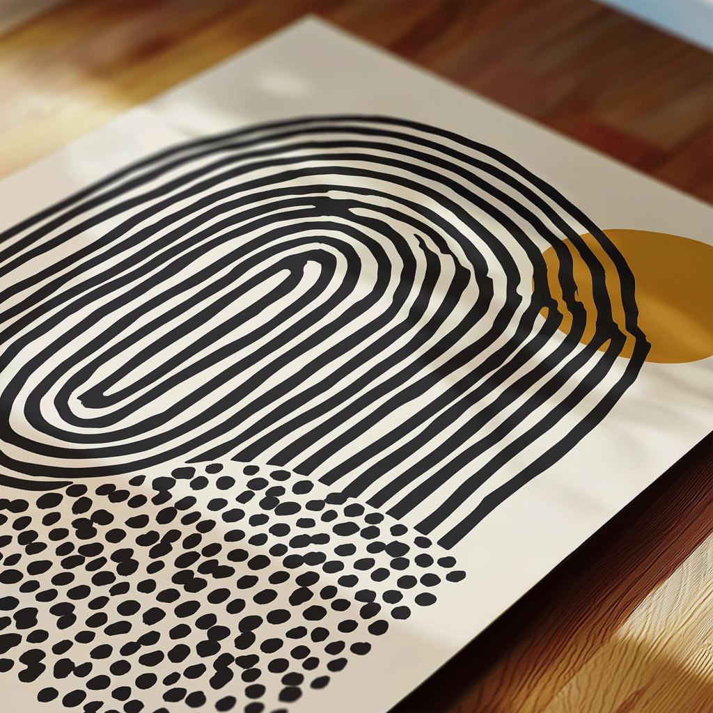 a close-up view of a piece of art with a striking abstract design. The artwork consists of a large, curved shape in black and white, with a smaller, circular shape in black and white with a polka dot pattern. The composition creates a visually interesting contrast between the two shapes.