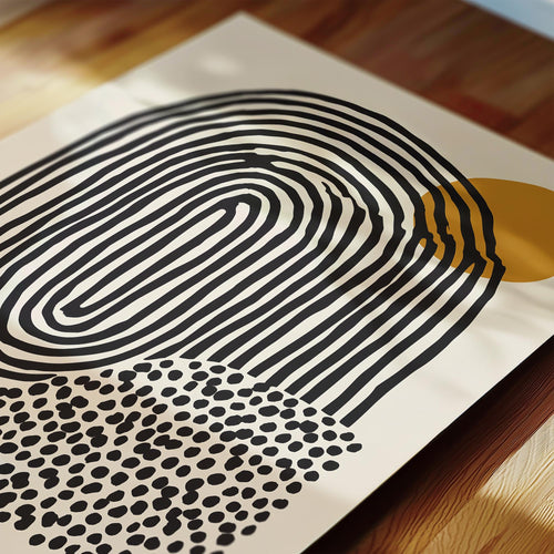 a close-up view of a piece of art with a striking abstract design. The artwork consists of a large, curved shape in black and white, with a smaller, circular shape in black and white with a polka dot pattern. The composition creates a visually interesting contrast between the two shapes.