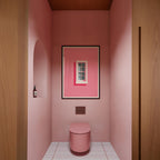 a bathroom with a pink wall, a white toilet, and a framed artwork of a window on the wall.