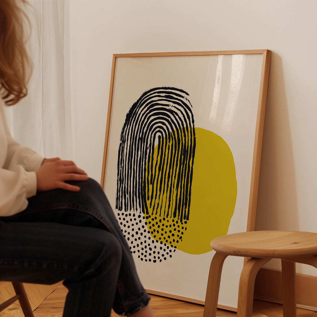 A person is sitting in a chair in front of a large abstract painting on the wall.