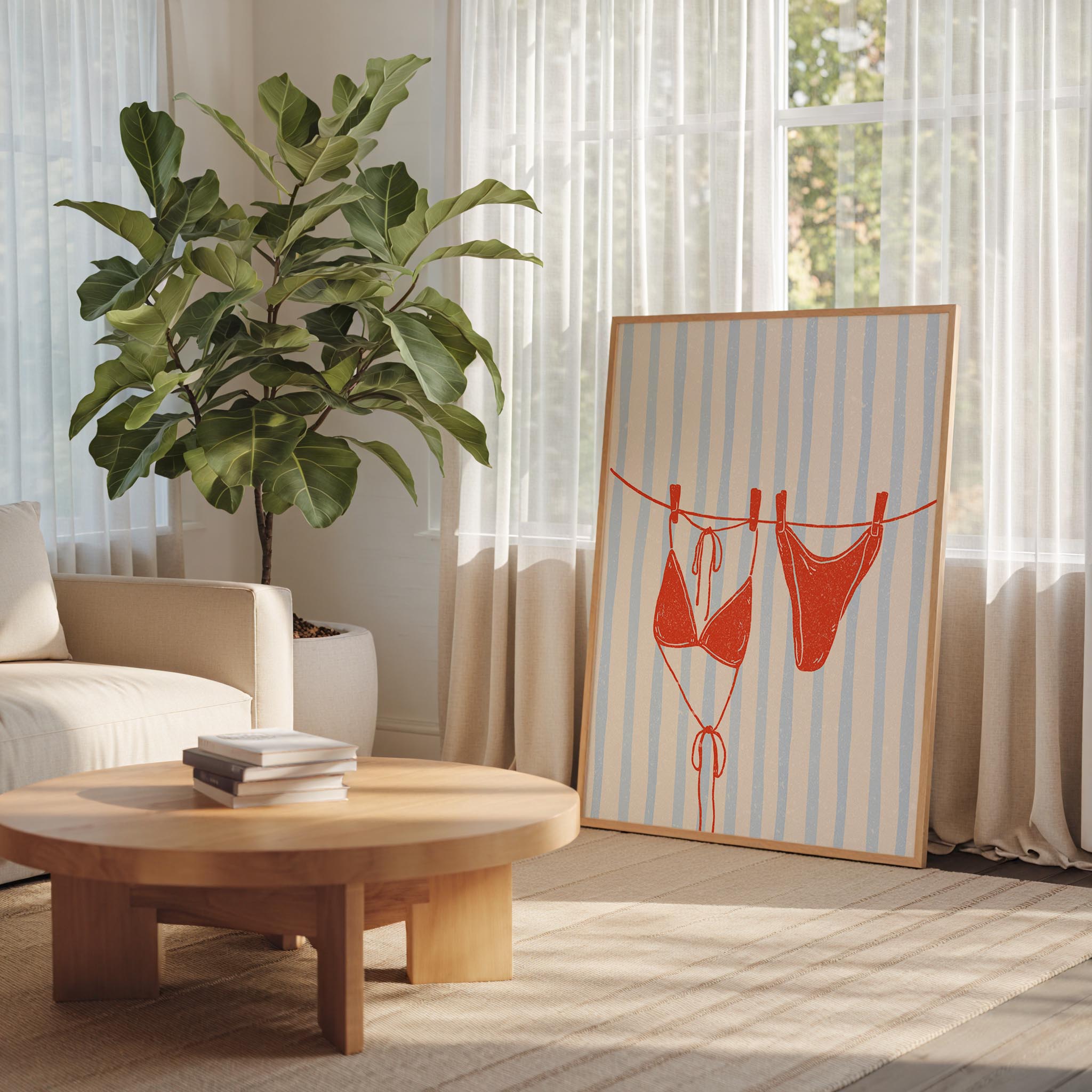 a living room with a large potted plant, a wooden coffee table, and a framed poster featuring a red bikini on a clothesline.