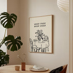 a framed poster with a simple illustration of a table set for a meal, accompanied by the text "GOOD FOOD GOOD MIND" above it.