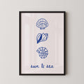 The image is a framed print with three blue illustrations of seashells and a text that reads "sun & sea".