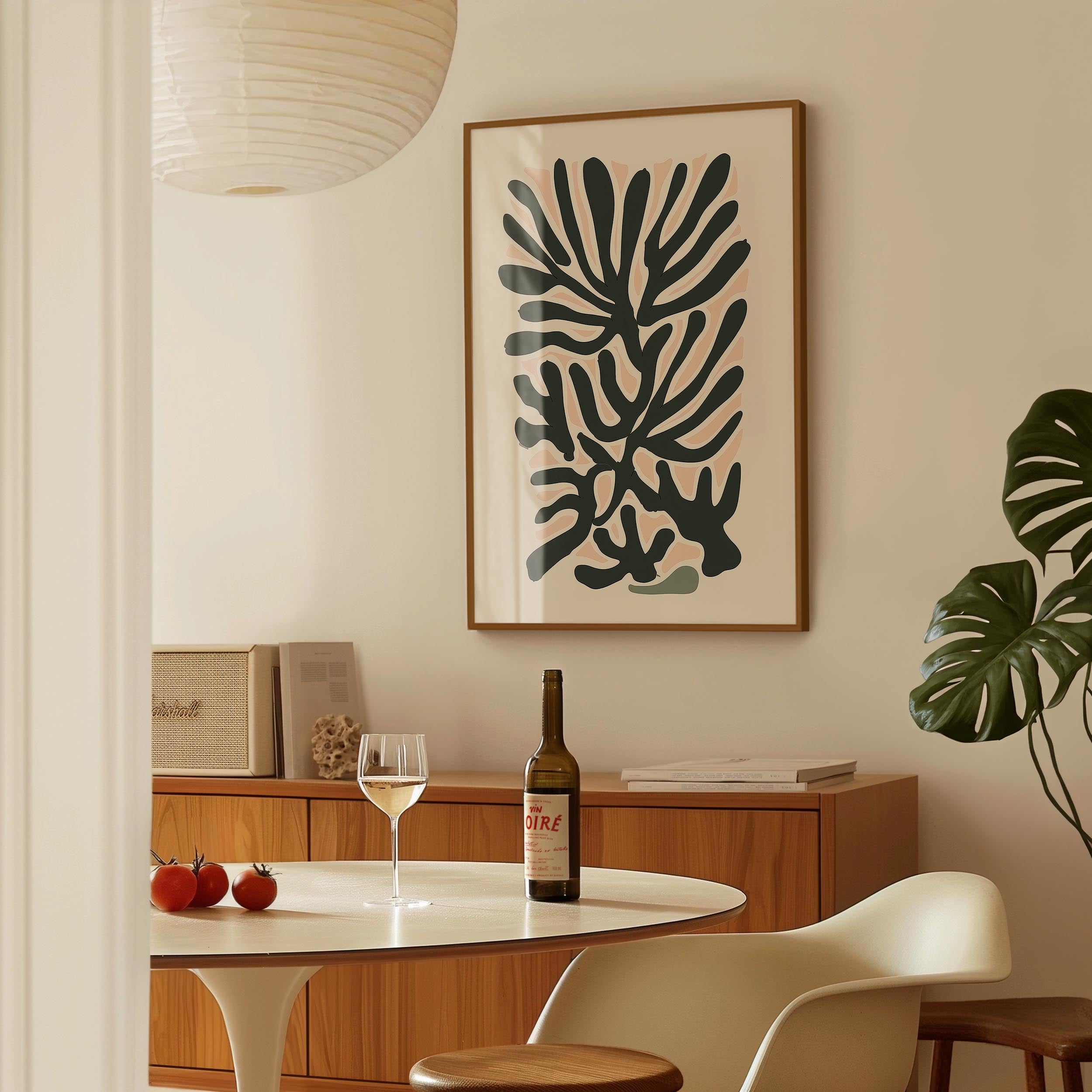 a dining area with a table, a bottle of wine, and a framed abstract art piece on the wall.