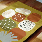 The image is a vibrant abstract artwork featuring a variety of shapes and colors, including white, orange, green, and brown.