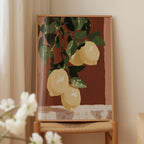 a painting of lemons hanging on a wall, displayed on a wooden frame.