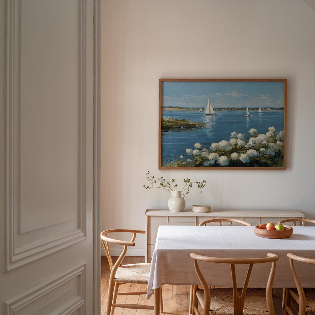 a serene dining room with a white table and chairs, a vase of flowers, and a painting of a sailboat on the wall.