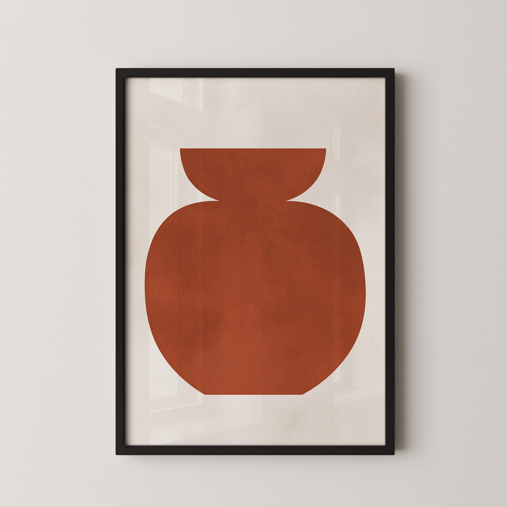 a simple, abstract design of a large orange shape, which appears to be a vase or container, displayed in a black frame on a white wall.