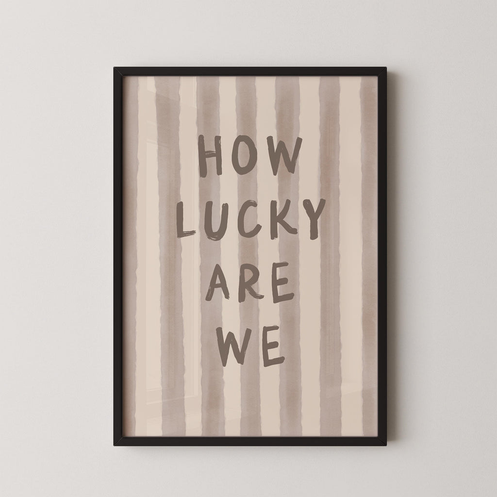a framed print with the text "HOW LUCKY ARE WE" written on it.