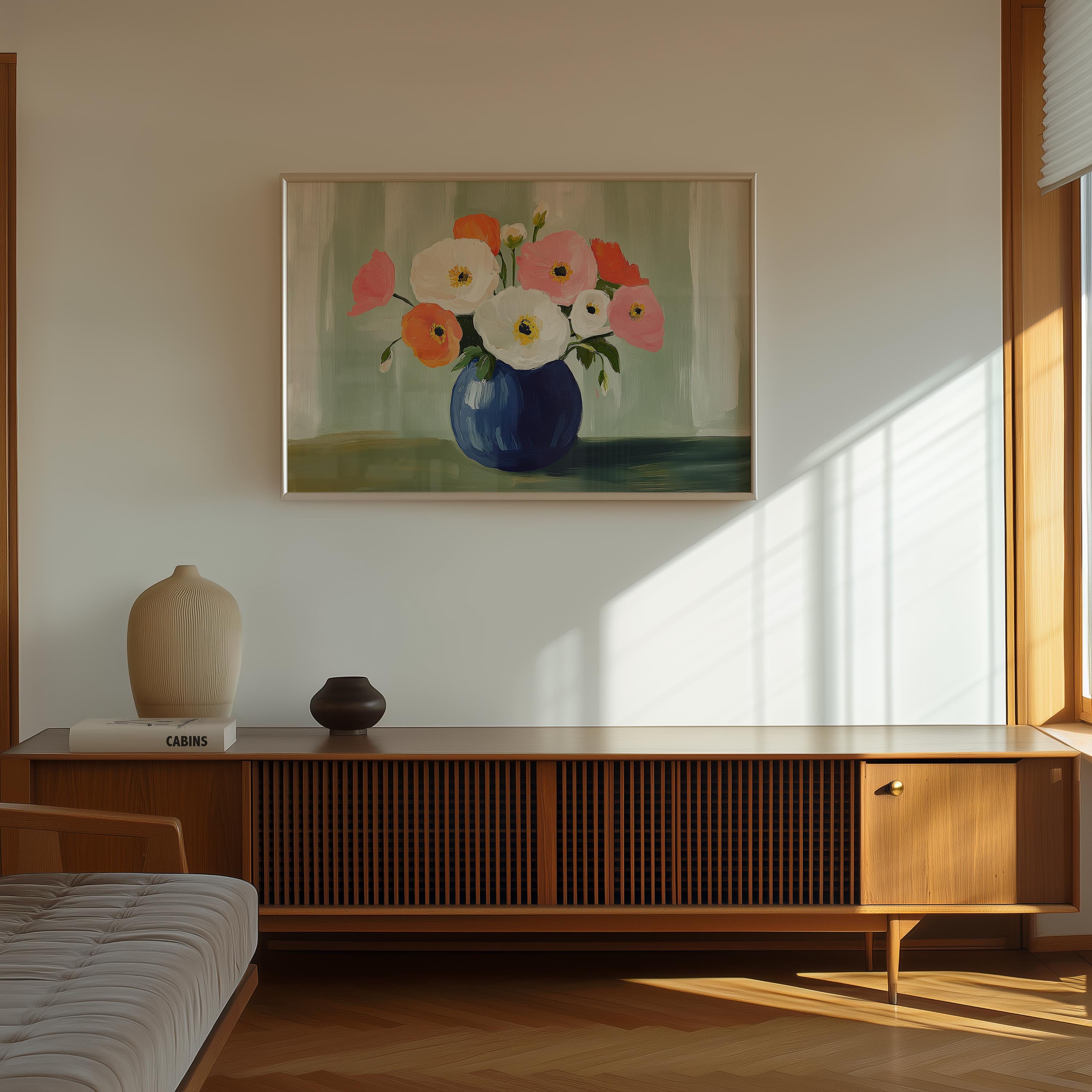 a wooden cabinet with a vase of colorful flowers on top, and a framed painting of flowers hanging on the wall above it.