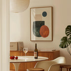 a dining room with a table set for two, a bottle of wine, and a framed abstract painting on the wall.