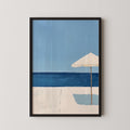 A framed painting depicting a beach scene with a white umbrella and a blue sky.