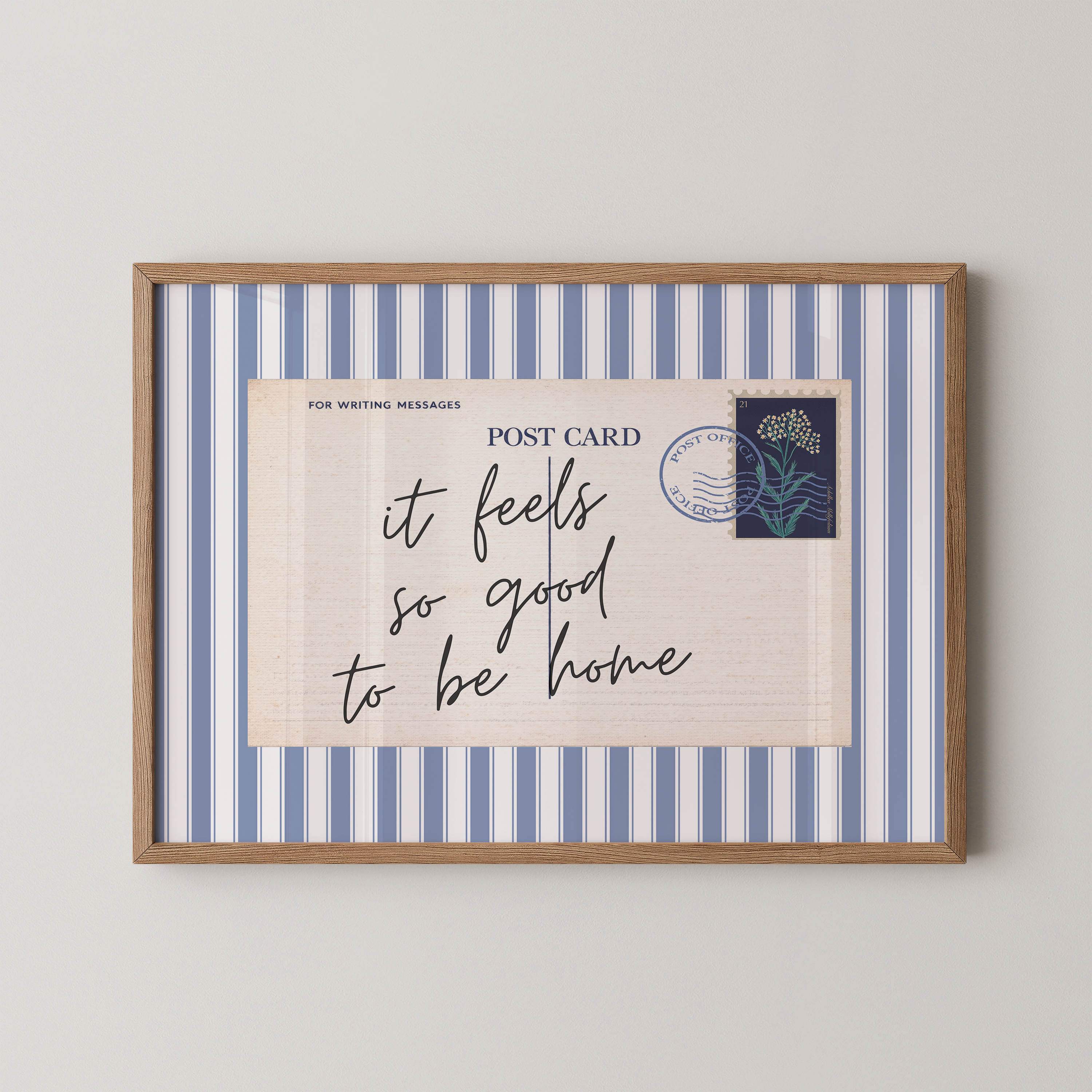 The image is a framed print with a blue and white striped border, featuring a handwritten message that reads "it feels so good to be home".