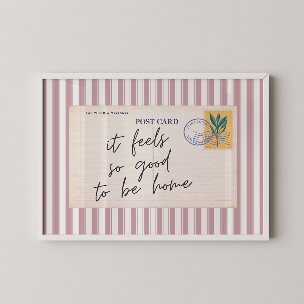 The image is a framed postcard with a handwritten message that reads "it feels so good to be home".