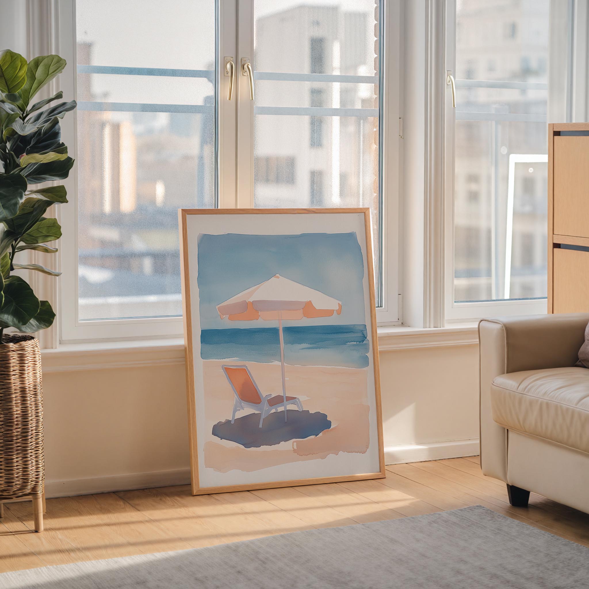 a large framed painting depicting a beach scene with a beach umbrella and a lounge chair, placed on a wooden floor in a room with large windows overlooking a cityscape.