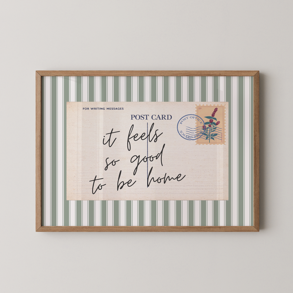 a framed postcard with a handwritten message that reads "it feels so good to be home".