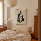 a bedroom with a bed, a lamp, and a framed artwork on the wall.