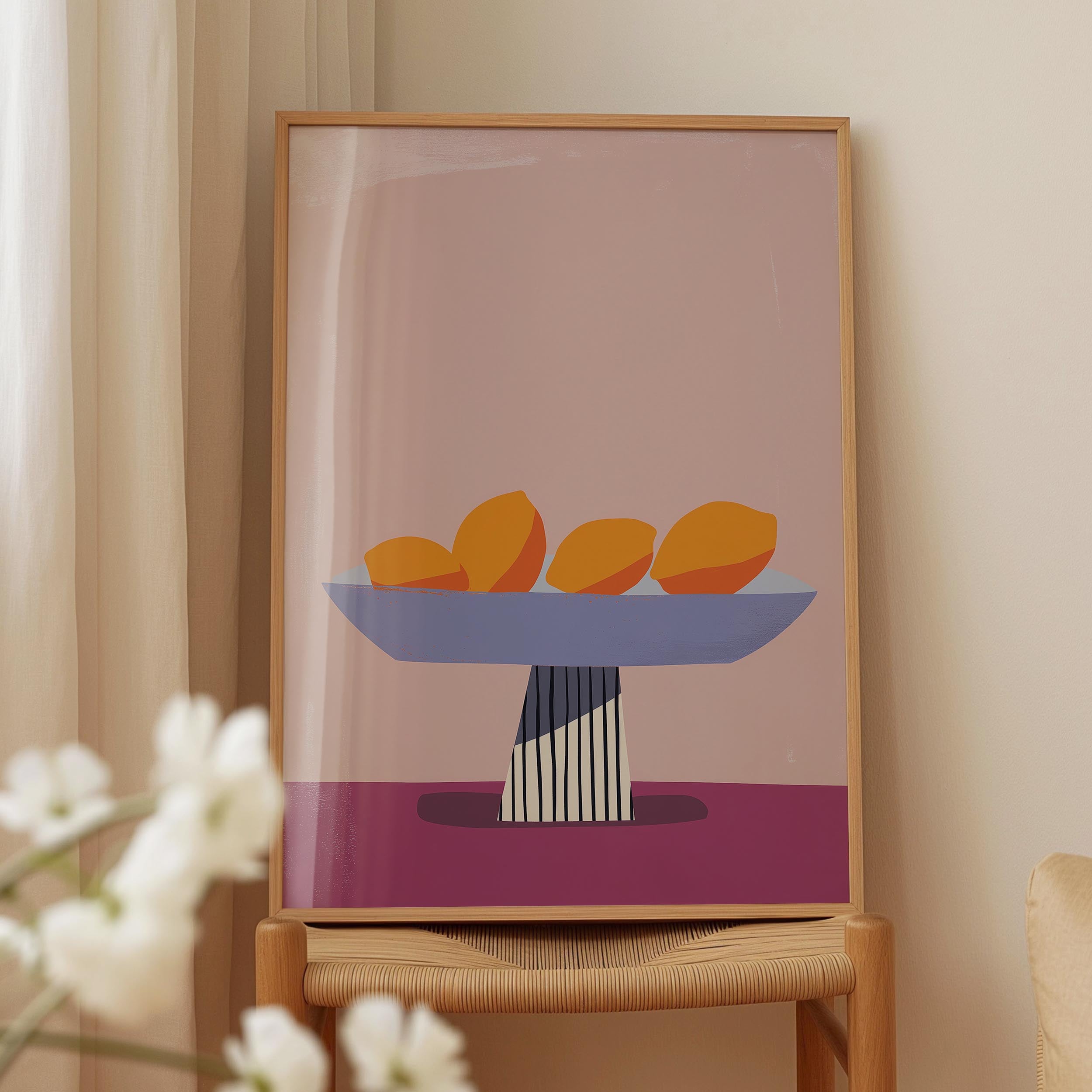 a framed illustration of a bowl of fruit, specifically oranges, placed on a wooden table.