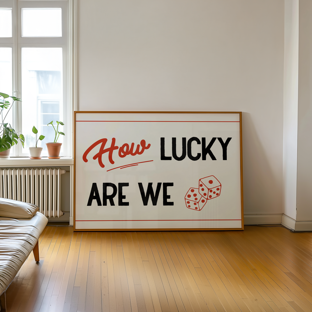 A large framed sign with the text "How LUCKY ARE WE" and two dice graphics is displayed in a room with a window and a plant.