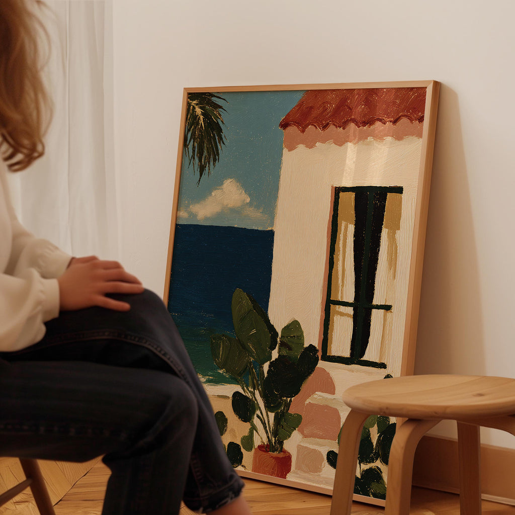 A person is sitting in front of a large painting depicting a tropical scene with a house, palm tree, and blue sky.
