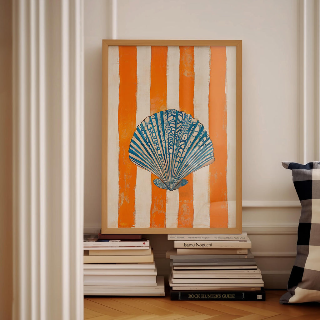 a framed artwork of a seashell on a white wall, with a stack of books below it.