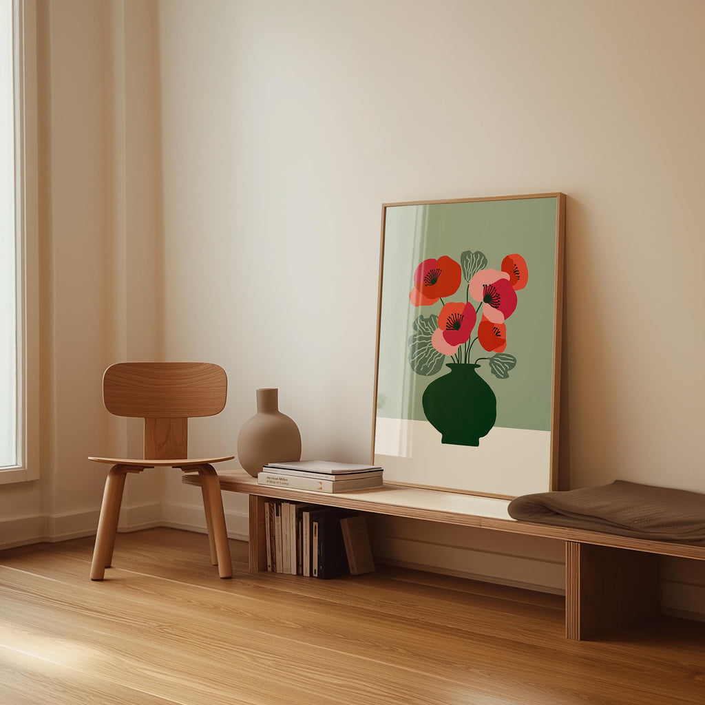 a minimalist interior design with a wooden chair, a wooden bench, a vase, and a framed poster of red flowers on a green background.