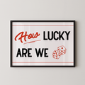 A framed poster with the text "How LUCKY ARE WE" and two dice graphics.