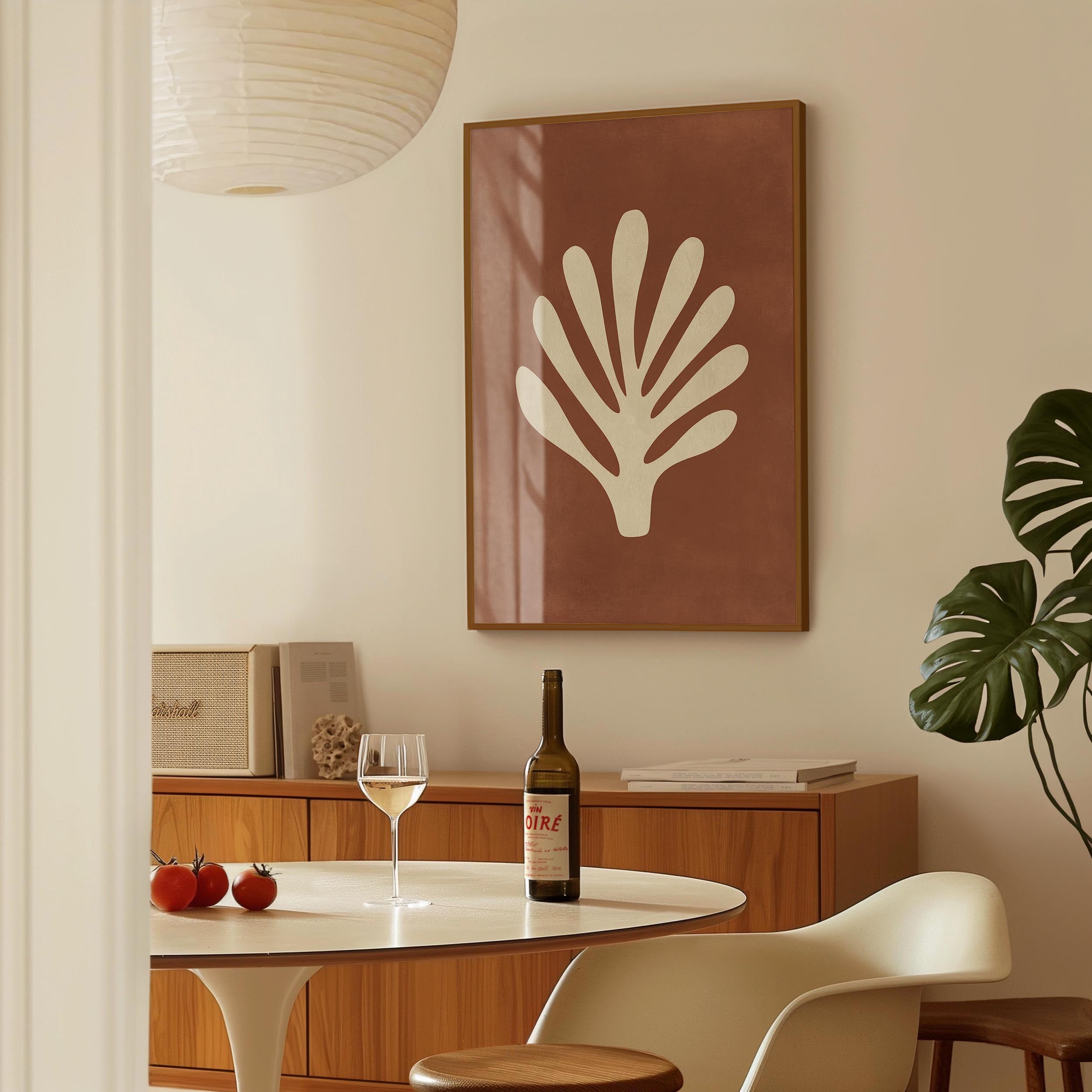 a dining room with a table set for two, a bottle of wine, and a framed artwork on the wall.