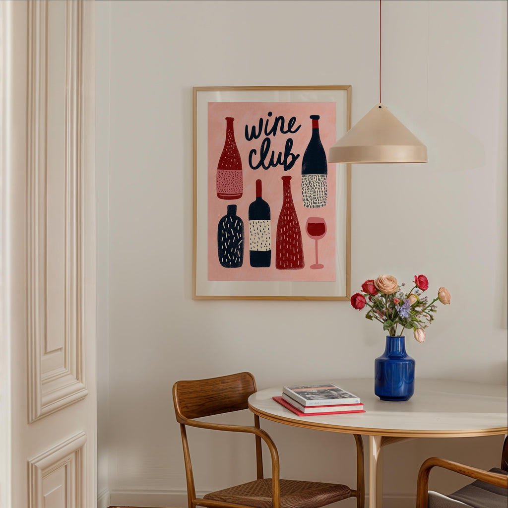 a dining area with a table, chairs, and a framed poster of wine bottles on the wall.