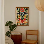 a cozy corner of a room with a wooden chair, a small table with books, and a large, colorful floral print hanging on the wall.