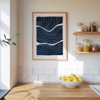 a kitchen counter with a bowl of lemons, a framed abstract art piece, and shelves displaying various jars and containers.