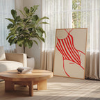 a living room with a large potted plant, a wooden coffee table, and a framed artwork featuring a red and white striped design.