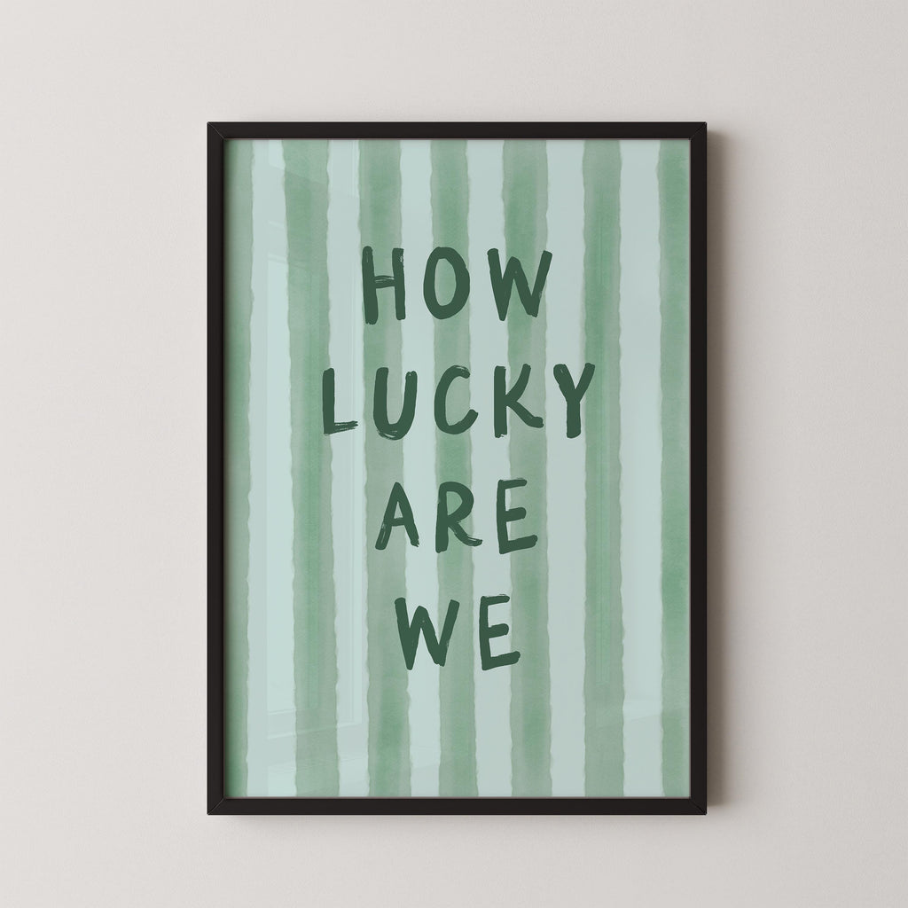 a framed poster with the text "HOW LUCKY ARE WE" written on it.